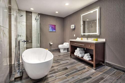 DoubleTree By Hilton Halifax Dartmouth في هاليفاكس: حمام مع حوض ومغسلة ومرحاض
