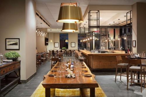 a restaurant with a long table and a bar at Doubletree By Hilton Greeley At Lincoln Park in Greeley