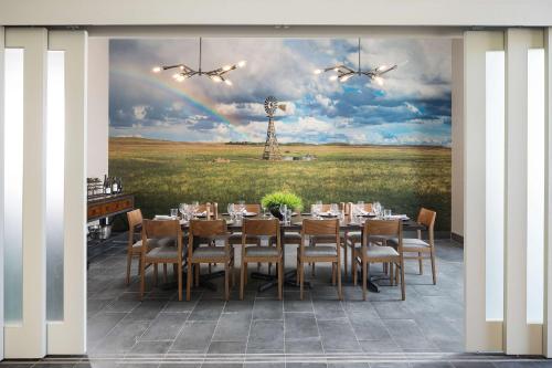 a dining room with a table and a rainbow at Doubletree By Hilton Greeley At Lincoln Park in Greeley
