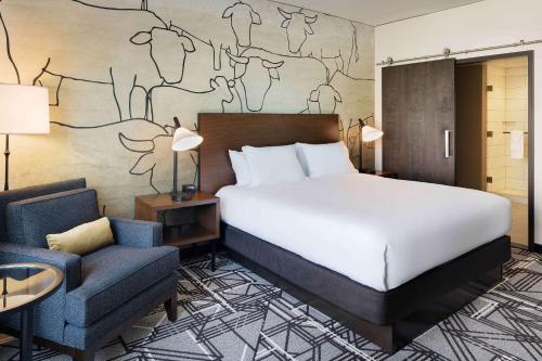 a hotel room with a bed and a chair at Doubletree By Hilton Greeley At Lincoln Park in Greeley