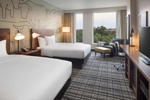 格里利的住宿－Doubletree By Hilton Greeley At Lincoln Park，一间酒店客房,设有两张床和电视