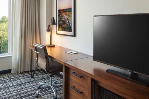 a hotel room with a desk with a flat screen tv at Doubletree By Hilton Greeley At Lincoln Park in Greeley