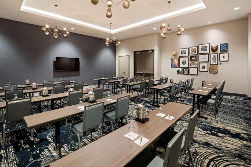 a conference room with tables and chairs and a flat screen tv at Doubletree By Hilton Greeley At Lincoln Park in Greeley