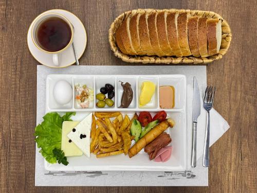 bandeja con un plato de comida y una taza de café en TRABZON Asel Suite Otel, en Trabzon