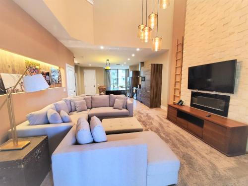 a living room with a blue couch and a tv at 3045 Magic Village8 guests 4 suites BBQ 8 min Disney in Orlando