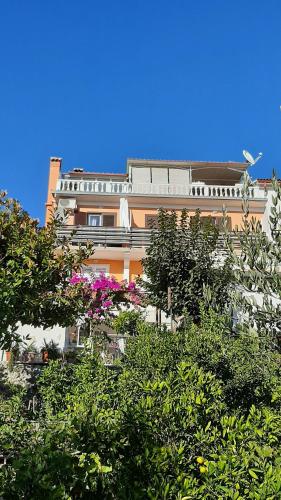 um edifício alto com árvores em frente em Apartment Milica em Rab