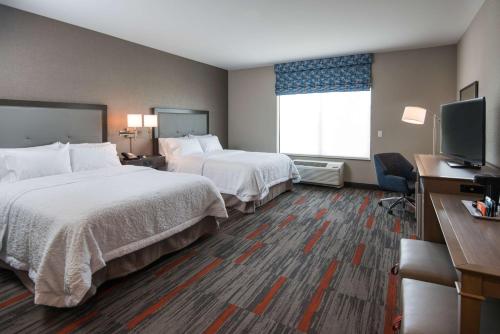 a hotel room with two beds and a flat screen tv at Hampton Inn and Suites at Wisconsin Dells Lake Delton in Wisconsin Dells