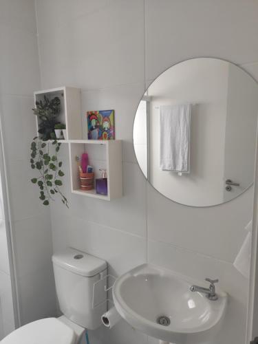 a white bathroom with a toilet and a sink at Aruana Azul 502 - Apto com AR, PISCINA, Varanda Integrada - Aluguel por Temporada in Aracaju