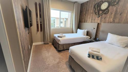 een hotelkamer met twee bedden en een klok aan de muur bij 3053 Magic Village 3 suites jacuzzi BBQ 6min Disney in Orlando