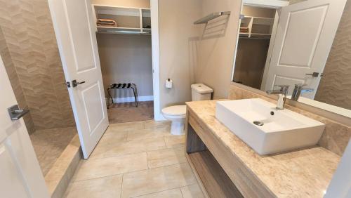 een badkamer met een witte wastafel en een toilet bij 3053 Magic Village 3 suites jacuzzi BBQ 6min Disney in Orlando