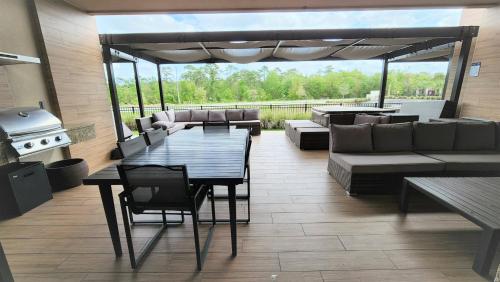 a patio with a couch and a table and a grill at 3053 Magic Village 3 suites jacuzzi BBQ 6min Disney in Orlando