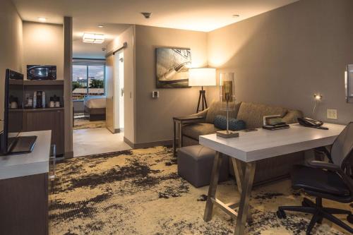 a living room with a desk and a couch and a table at Hilton Garden Inn Pittsburgh Airport in Moon Township