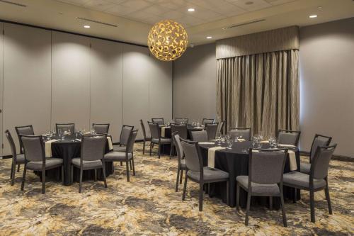 a conference room with tables and chairs and a chandelier at Hilton Garden Inn Pittsburgh Airport in Moon Township