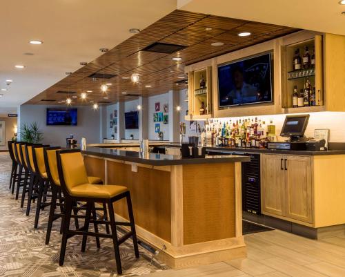 a bar with a row of chairs at a restaurant at Hilton Garden Inn Pittsburgh Airport in Moon Township