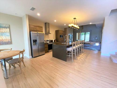 a kitchen and dining room with a table and chairs at 7589 Magic Village 8 guests 4 suites BBQ near 192 Disney in Orlando