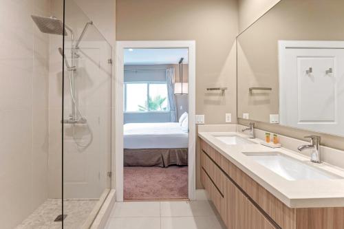 a bathroom with two sinks and a shower with a bed at 7562 Magic Village nice 8guests 4suites 8 min Disney in Orlando
