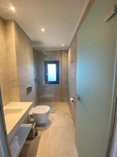 een badkamer met een toilet en een glazen douche bij OliVISTA - Live in Nature in Astris