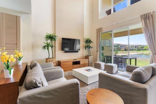 a living room with two couches and a tv at 3212 Magic Village 8 guests lakefront 8 min Disney in Orlando