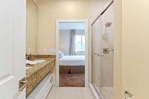 a bathroom with a mirror and a sink and a bed at 3212 Magic Village 8 guests lakefront 8 min Disney in Orlando