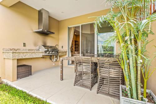 a patio with a grill and a table and chairs at 3212 Magic Village 8 guests lakefront 8 min Disney in Orlando