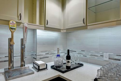 オーロラにあるHomewood Suites by Hilton Aurora Napervilleのキッチン(カウンター、ワインボトル、グラス付)