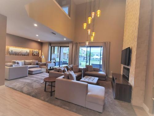 a living room with white couches and a tv at 7564 Magic Village 3 suites jacuzzi BBQ 8 min Disney in Orlando