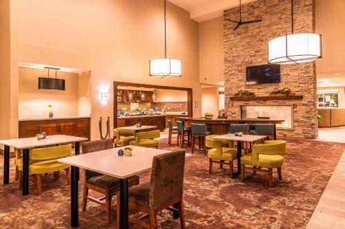 Un restaurante con mesas y sillas y una chimenea. en Homewood Suites by Hilton Pleasant Hill Concord, en Pleasant Hill
