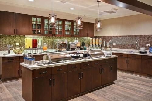 een grote keuken met houten kasten en roestvrijstalen apparatuur bij Homewood Suites by Hilton Pleasant Hill Concord in Pleasant Hill