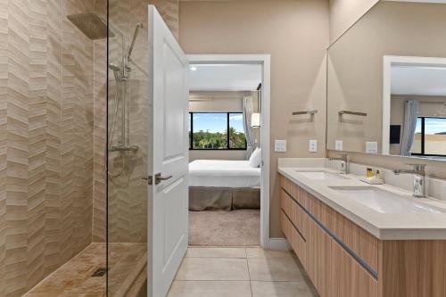 a bathroom with a shower and a sink and a bed at 7564 Magic Village luxury jacuzzi bbq 6min Disney & 192 in Orlando