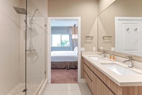 a bathroom with two sinks and a shower with a bed at 7462 Magic Village 8guests 4suites near Disney and 192 in Orlando