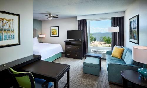 a hotel room with a bed and a couch at Homewood Suites By Hilton North Bay in North Bay