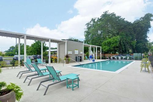 a patio with chairs and a swimming pool at Home2 Suites Pensacola I-10 At North Davis Hwy in Pensacola