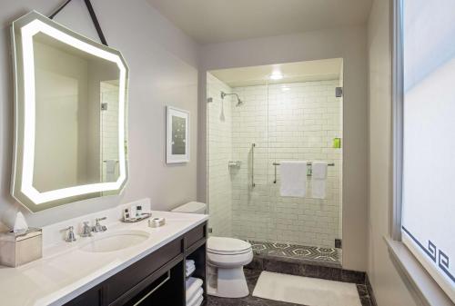 a bathroom with a sink and a toilet and a shower at The Virginian Lynchburg, Curio Collection By Hilton in Lynchburg