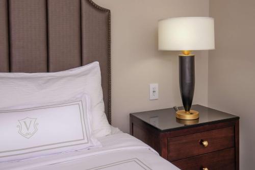a bedroom with a bed with a lamp on a night stand at The Virginian Lynchburg, Curio Collection By Hilton in Lynchburg