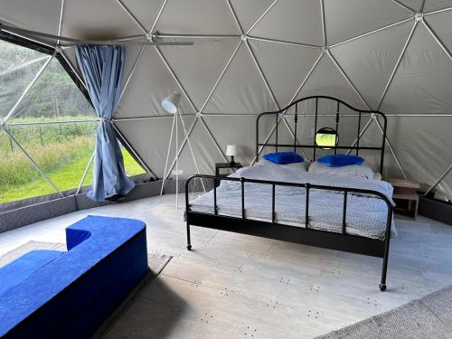 Glamping Stodoła Dome في Ściegny: غرفة نوم بسرير في خيمة