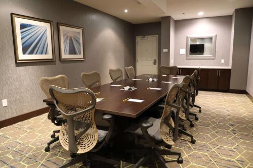 a conference room with a wooden table and chairs at Hilton Garden Inn Austin Airport in Austin