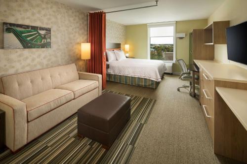 a hotel room with a bed and a couch at Home2 Suites By Hilton Mishawaka South Bend in Mishawaka