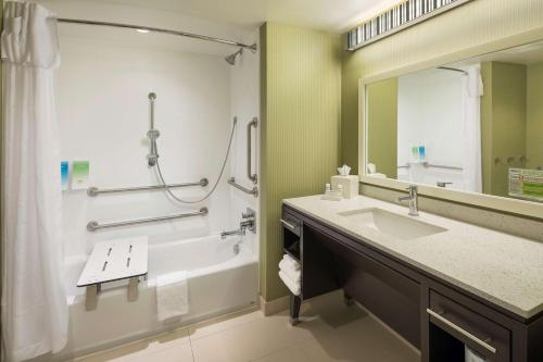 a bathroom with a tub and a sink and a shower at Home2 Suites By Hilton Mishawaka South Bend in Mishawaka