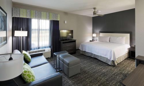 une chambre d'hôtel avec un lit et un canapé dans l'établissement Homewood Suites By Hilton Topeka, à Topeka