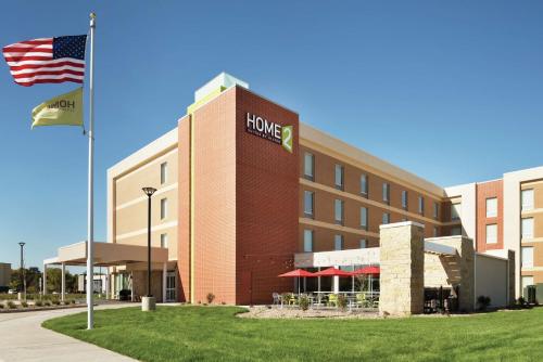 a hotel with an american flag in front of it at Home2 Suites By Hilton Iowa City Coralville in Coralville
