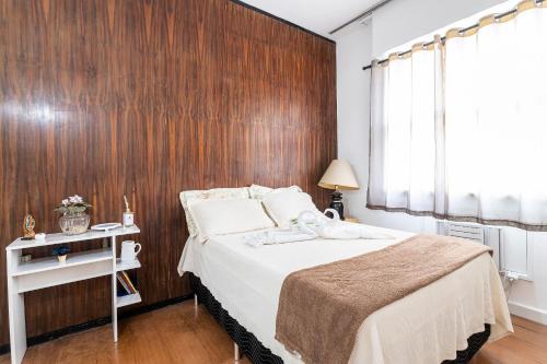 1 dormitorio con 1 cama y pared de madera en Apto com Wi-Fi a 200m da Praia de Copacabana/RJ - Cp2, en Río de Janeiro