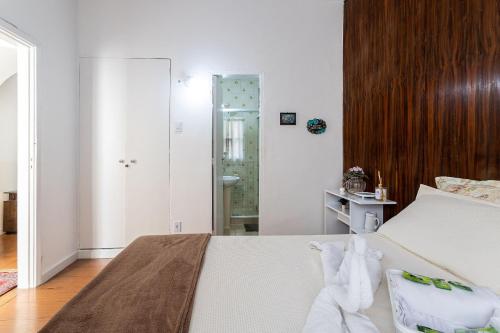 1 dormitorio con cama blanca y baño en Apto com Wi-Fi a 200m da Praia de Copacabana/RJ - Cp2, en Río de Janeiro