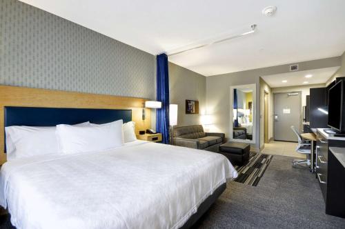 a hotel room with a large bed and a living room at Home2 Suites By Hilton Mt. Juliet, Tn in Mount Juliet