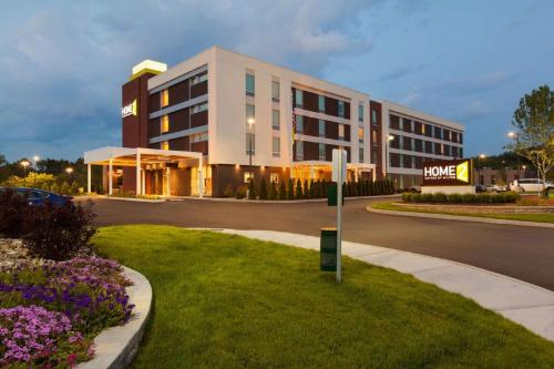a large building with a sign in front of it at Home2 Suites by Hilton Albany Airport/Wolf Rd in Albany