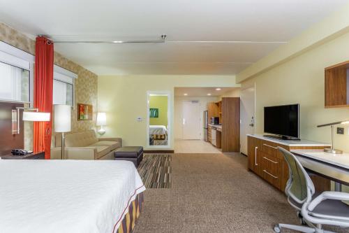 a hotel room with a bed and a living room at Home2 Suites by Hilton Albany Airport/Wolf Rd in Albany
