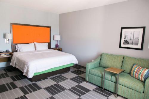 a hotel room with a bed and a couch at Hampton Inn & Suites Amarillo East in Amarillo