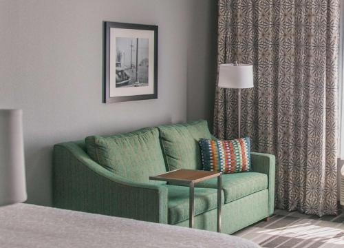a living room with a green couch and a table at Hampton Inn & Suites Amarillo East in Amarillo