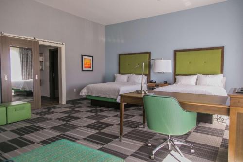 a hotel room with two beds and a desk and a desk at Hampton Inn & Suites Amarillo East in Amarillo