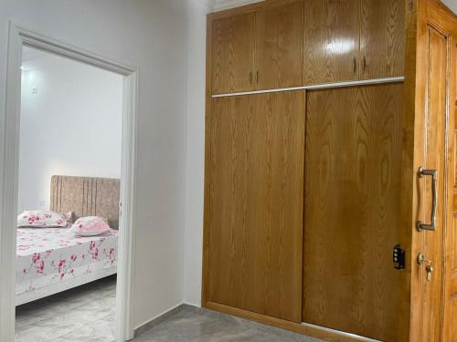a wooden door in a bedroom with a bed at Deluxe apartment in Kelibia