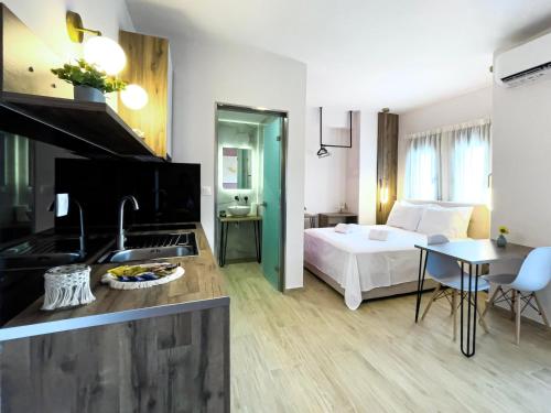 sypialnia z łóżkiem oraz kuchnia ze zlewem w obiekcie ATHONITE all seasons luxury suites w mieście Ierissós